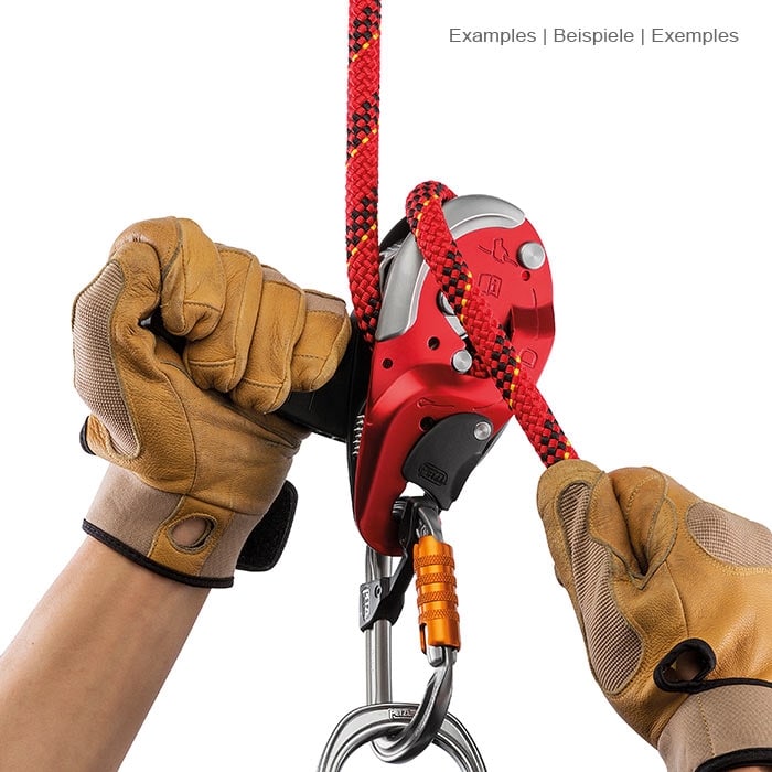 I’D L de Petzl, l’aire de jeux est tenue à deux mains avec des gants marrons, une corde rouge est enfilée et un mousqueton pend au fond