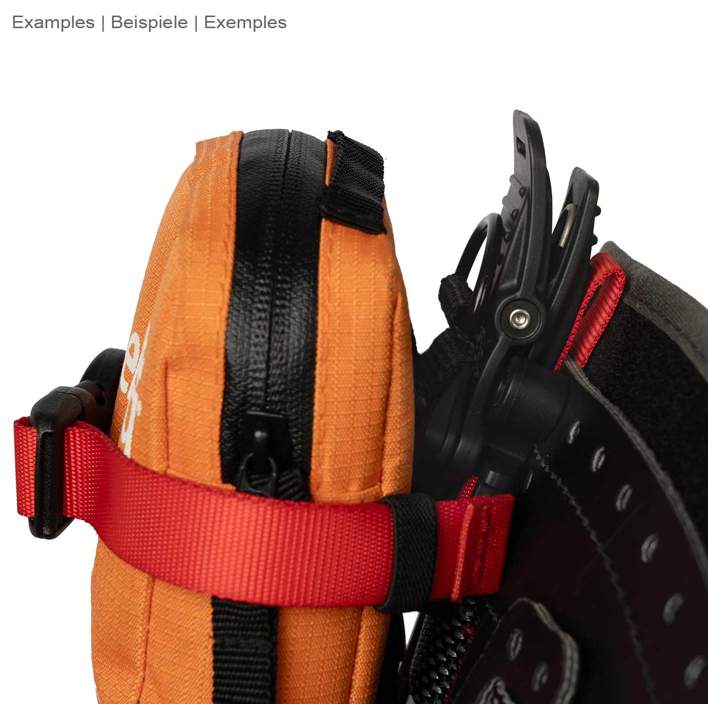 Caïman de DMM, ruban rouge attaché à un sac zippé orange avec fermeture velcro noire