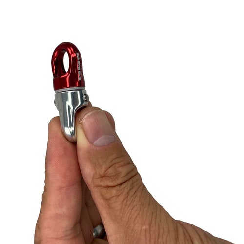 XSRE Swivel, tourbillon en métal rouge et argenté tenu entre le pouce et l’index, fond blanc