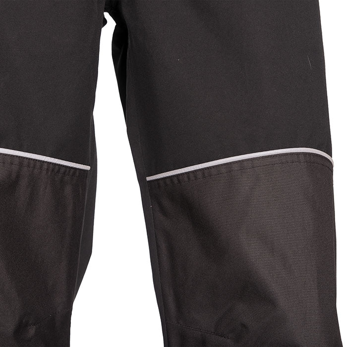 Gros plan des genoux du pantalon de pluie Keiu avec empiècements gris et bandes réfléchissantes