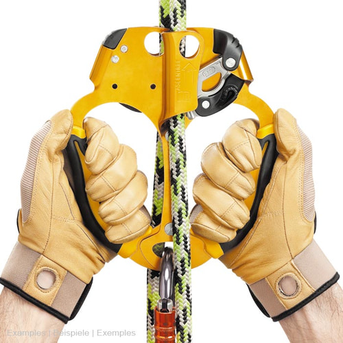 Aire de jeux jaune avec poignées noires, tenue par deux mains avec des gants beiges, entourée d’une corde