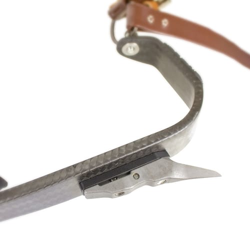 Gros plan d’une pièce incurvée en carbone avec bracelet en cuir marron et fermeture métallique