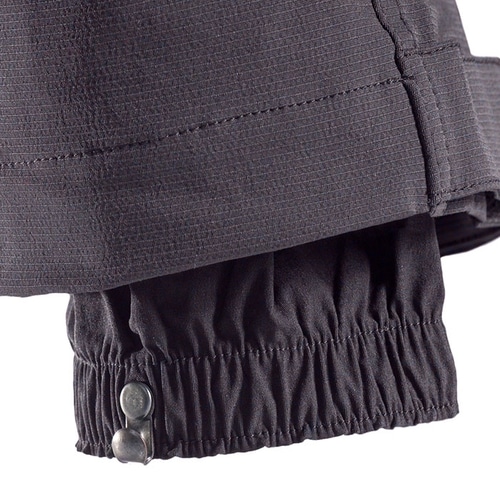 Pantalon d’escalade SIP, gros plan de l’ourlet de la jambe du pantalon avec ceinture élastique et deux boutons métalliques pour la fermeture