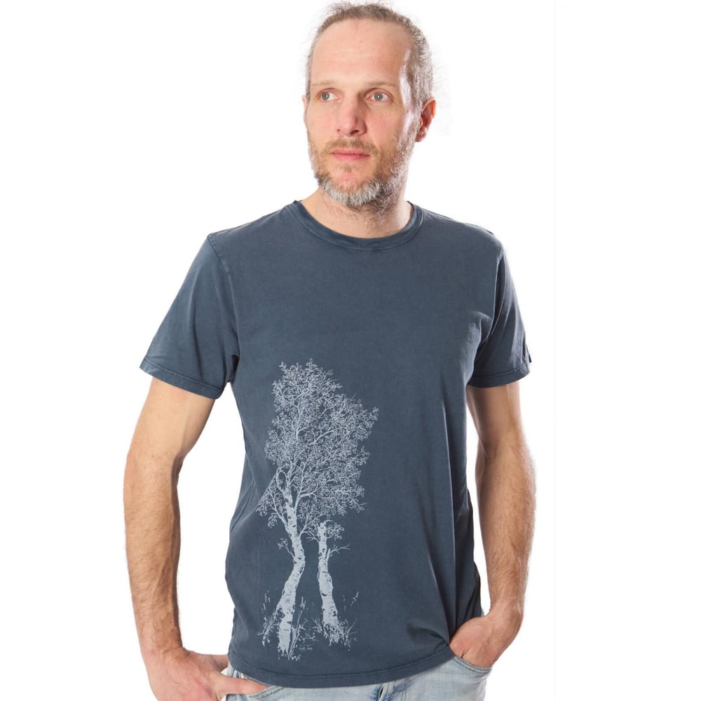 Homme portant un t-shirt bleu foncé en bouleau avec un motif d’arbre blanc sur le devant gauche