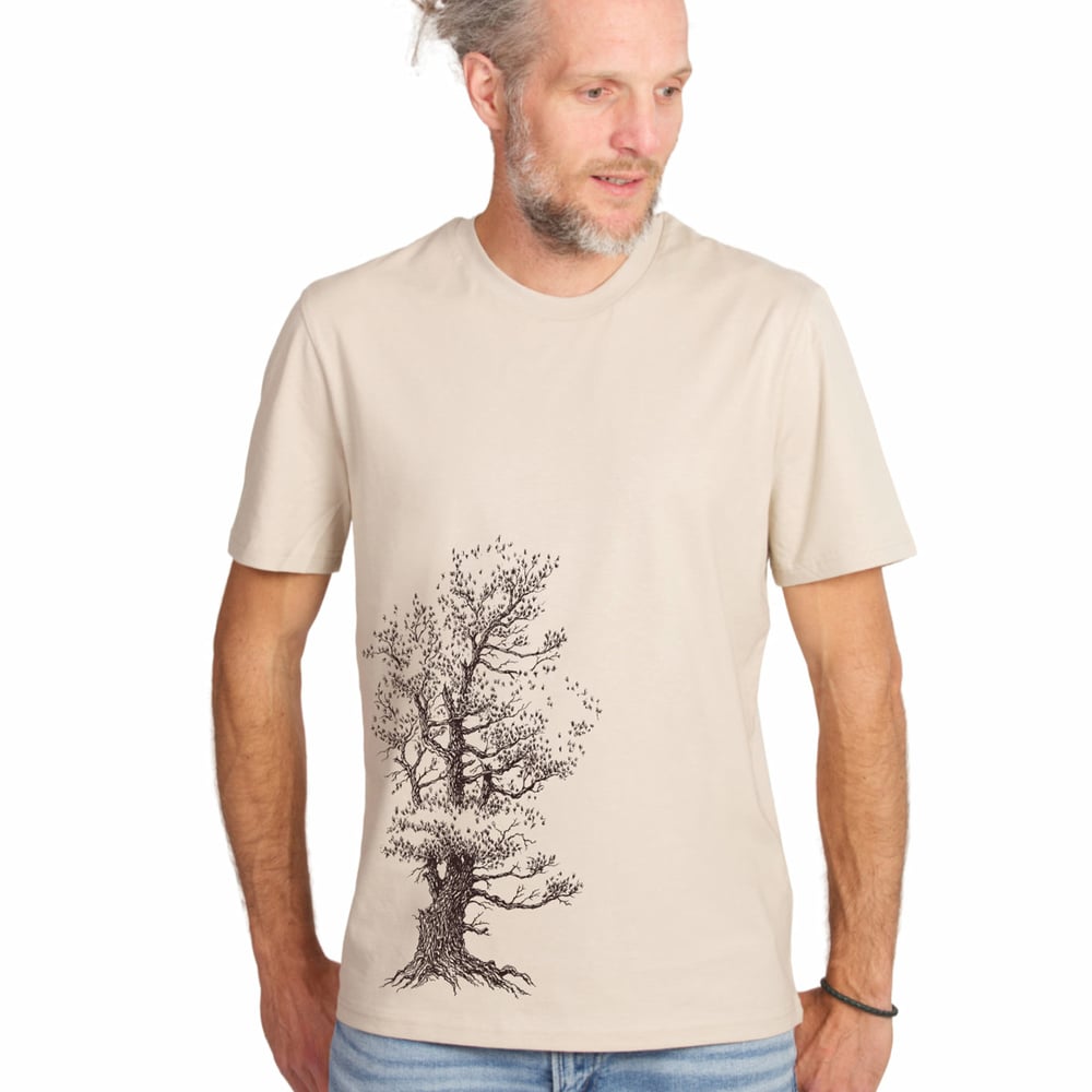 Homme portant un t-shirt de pin parasol en beige avec motif d’arbre noir, regardant vers la droite