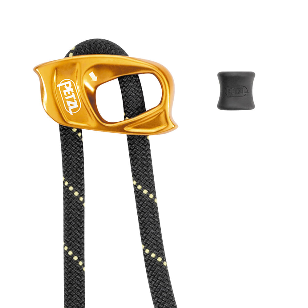 Gros plan de l’appareil en métal jaune avec le logo Petzl et la corde noire avec des points jaunes, à côté d’une petite pièce en caoutchouc noir avec le logo Petzl