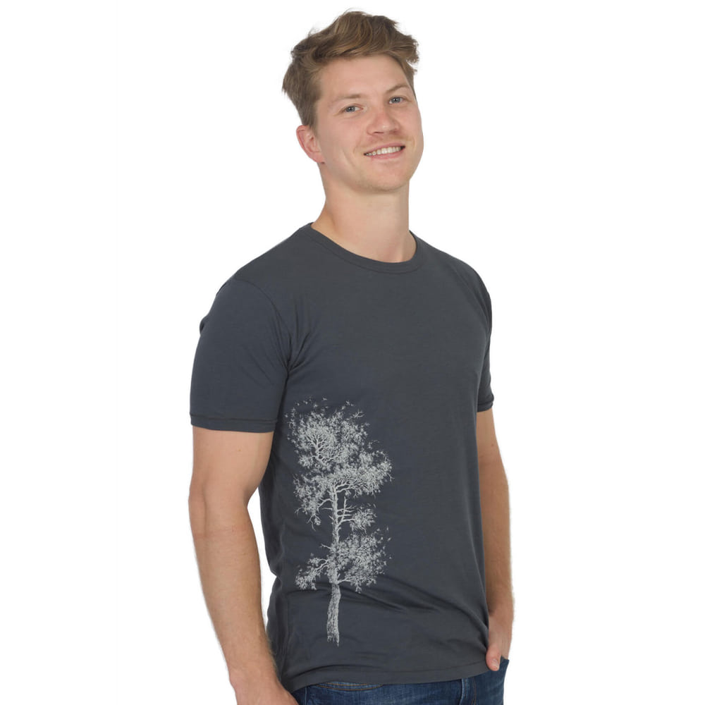 Homme portant un t-shirt Pine Tree gris foncé avec un imprimé d’arbre blanc sur le côté gauche du t-shirt.