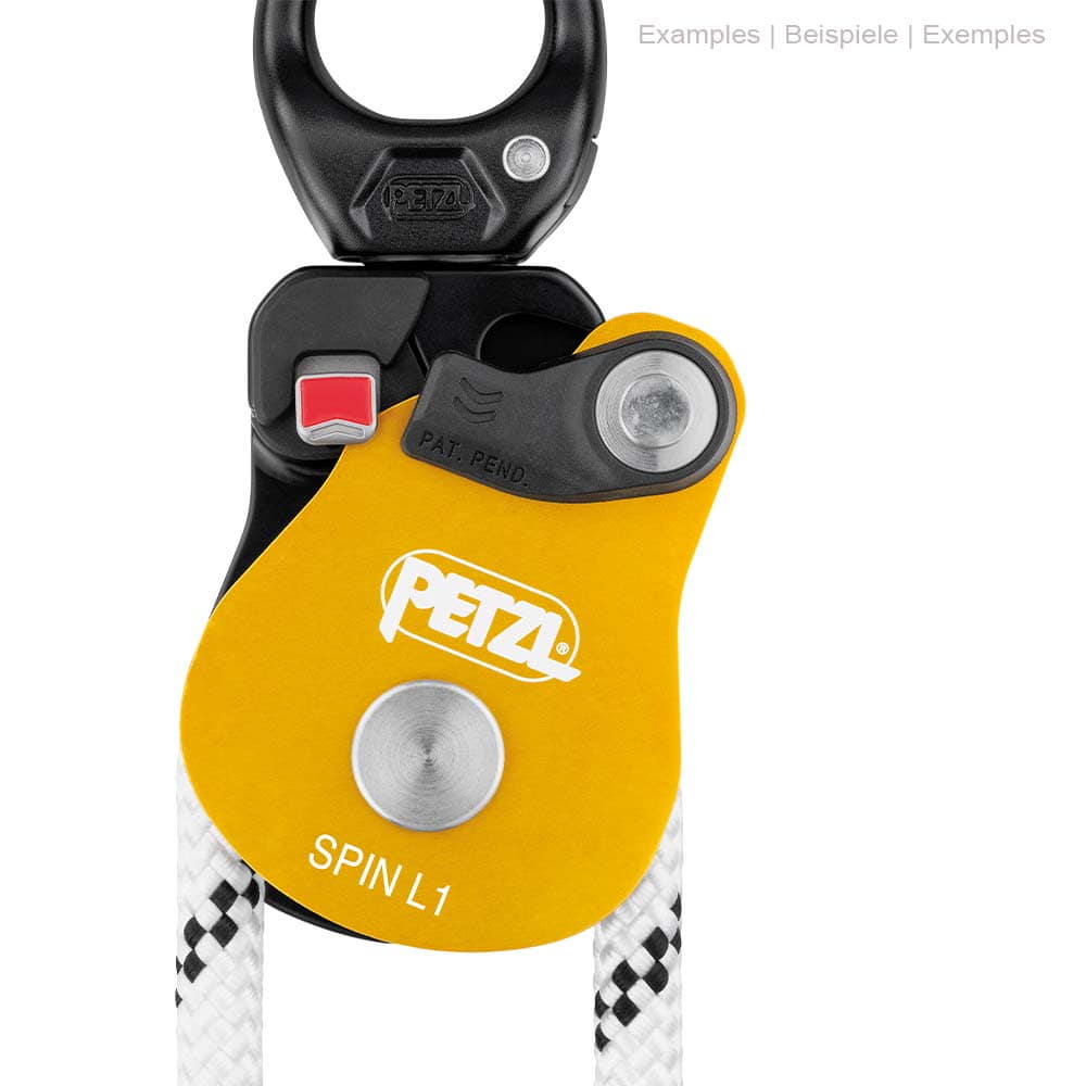 Gros plan de la poulie Petzl Spin L1 avec carter jaune, partie supérieure noire et corde blanche, bouton rouge et logo Petzl
