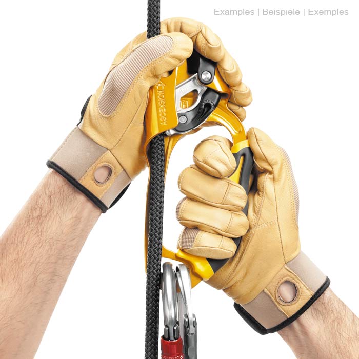 Ascension R en jaune et noir avec poignée, pièces métalliques, corde et mousqueton, tenu à deux mains avec des gants beiges