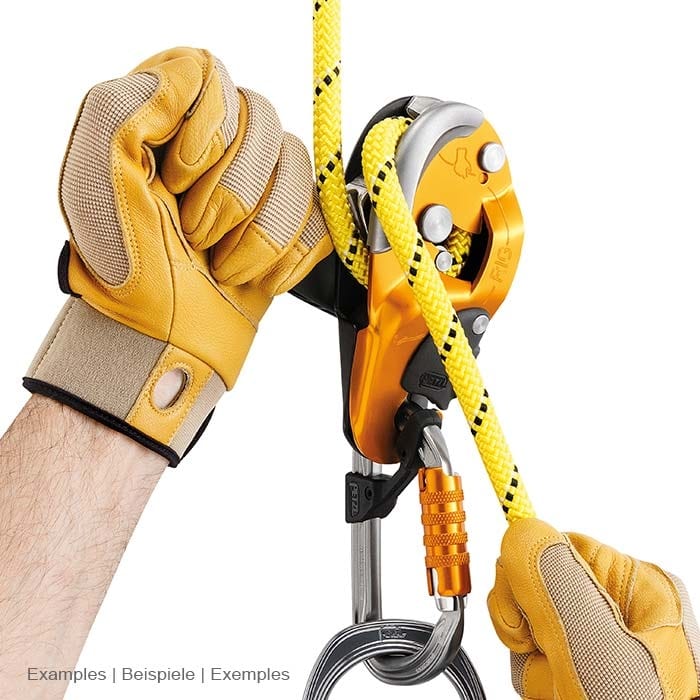 Dispositif d’assurage statique Petzl Rescue Rig en jaune avec corde et mousqueton jaunes, tenu par les mains avec des gants jaunes