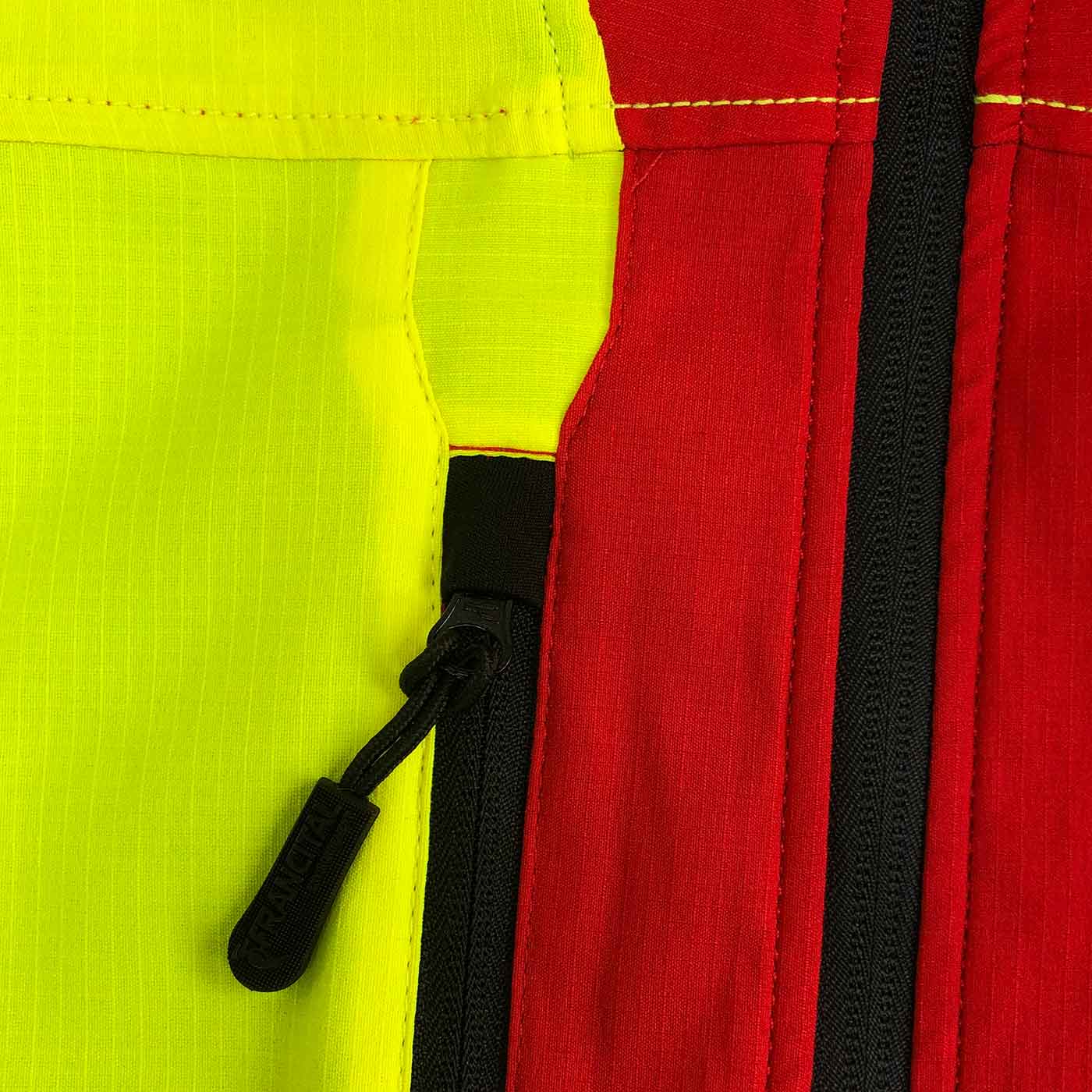 Gros plan de la fermeture éclair de la veste Grignan R en rouge et jaune avec fermeture éclair noire et surpiqûres jaunes