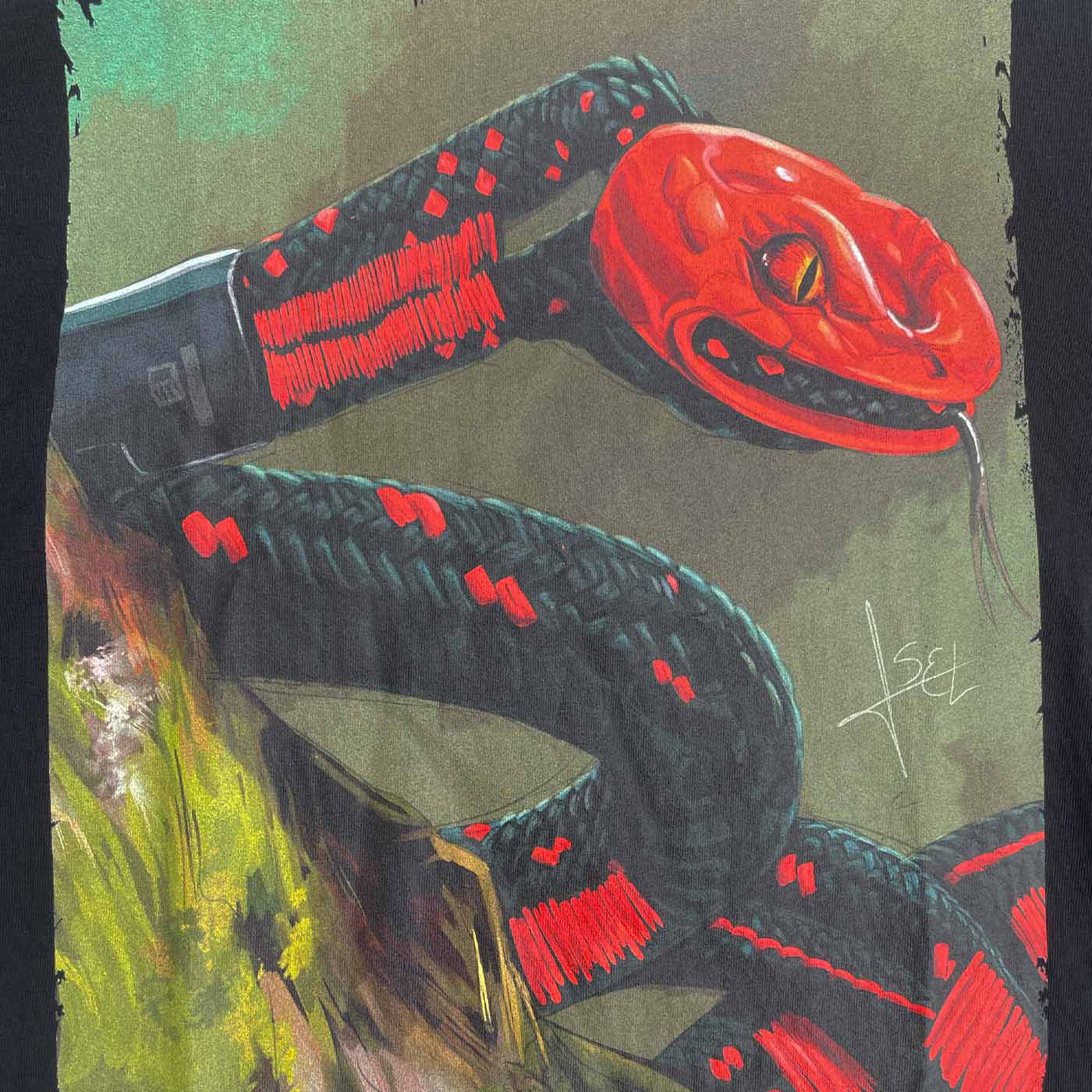 Gros plan du motif de serpent coloré sur une chemise de serpent ART noir avec des détails rouges et noirs et une zone de fond vert
