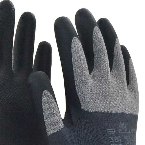Gros plan des gants de travail Showa 381, concentrez-vous sur le dos en tissu gris et le bout des doigts noir avec le nom du fabricant et le numéro de modèle visibles.