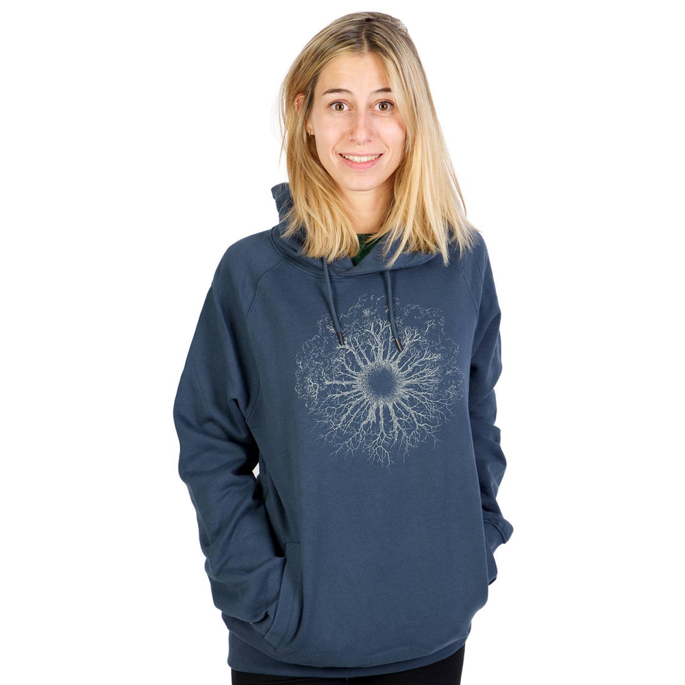 Une femme porte un sweat à capuche bleu Wooden Iris avec une capuche et un motif blanc en forme de racine d’arbre sur la poitrine.