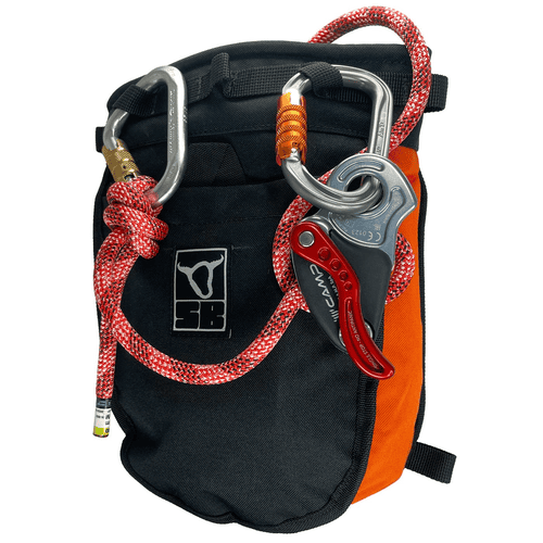 Rescue Druid Dynamic, pochette noire et orange avec corde d’escalade rouge et deux mousquetons, l’un avec fermoir doré et l’autre avec fermoir orange, un mécanisme de sécurité gris avec levier rouge est attaché à un mousqueton