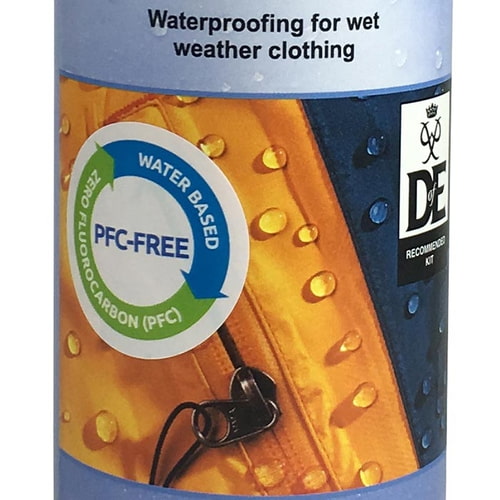 Gros plan de l’étiquette Nikwax TX-Direct Wash-In avec note sans PFC et gouttelettes d’eau sur fond jaune et bleu