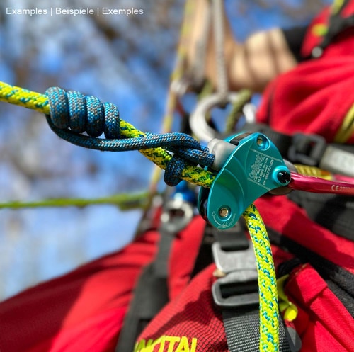 Appareil d’assurage Flexbee bleu avec corde d’escalade bleue et jaune, attaché à une personne avec une tenue d’escalade rouge