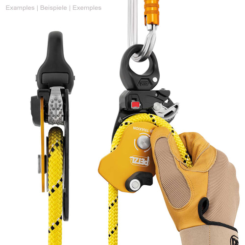 Poulie à corde Petzl Pro Traxion jaune et noire avec corde jaune, tenue d’une main avec un gant de travail, fixée sur le dessus avec un mousqueton argenté