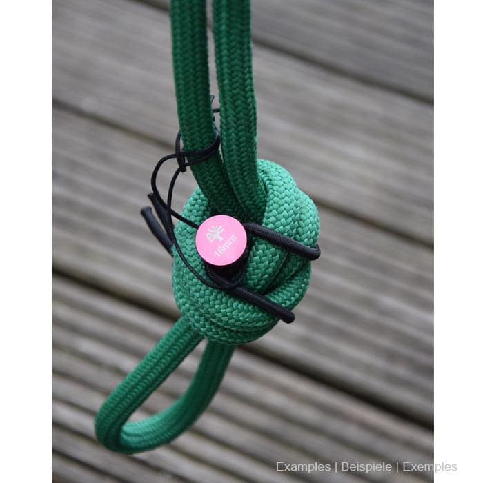 Ensemble d’épingles de corde épingle rouge sur corde verte avec des nœuds sur fond en bois