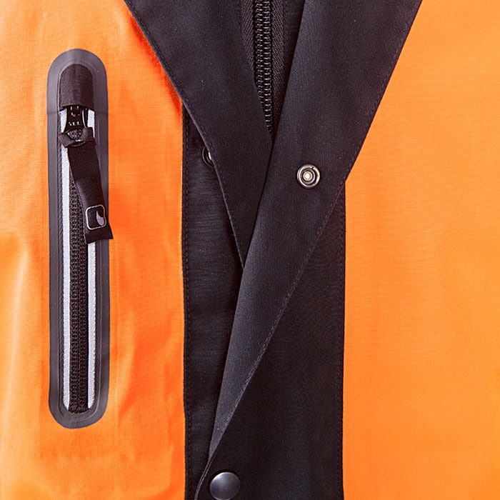 Gros plan de la poche poitrine avec fermeture éclair et de la patte de boutonnage noire à boutons-pression de la veste de pluie Keiu