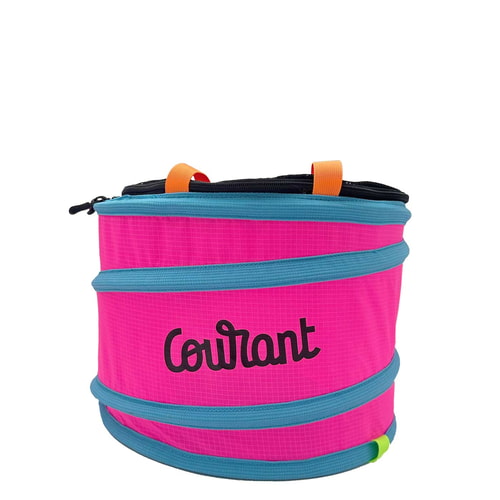Pelican M, contenant rond rose avec bords bleus et boucles de transport orange, le mot « Courant » en lettres noires sur le devant