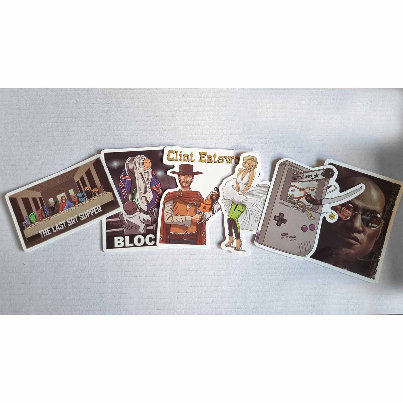 Six autocollants individuels du ARB Fiction Pack Vol. 2, dont « THE LAST SRT SUPPER » avec des personnages à une table, « BLOCKY » avec un personnage en robe blanche, Clint Eatswood avec une tronçonneuse, une femme en robe blanche et un pantalon vert, un 