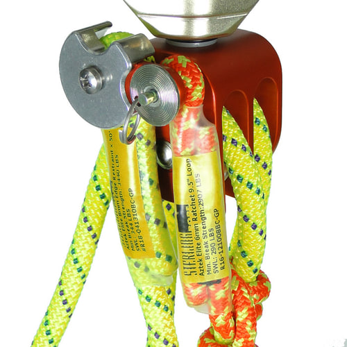 Gros plan sur la corde de sécurité Aztek de Petzl avec brins de corde jaune et orange, bloc métallique rouge et mécanisme de verrouillage en métal