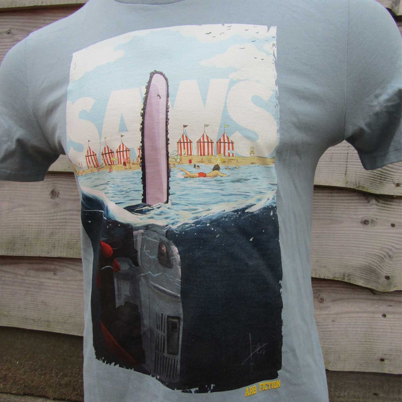 T-shirt gris avec une grande impression d’une tronçonneuse flottant librement dans l’eau, au-dessus de celui-ci le lettrage « SAWS » et dans la zone inférieure le texte « ARB FICTION ».