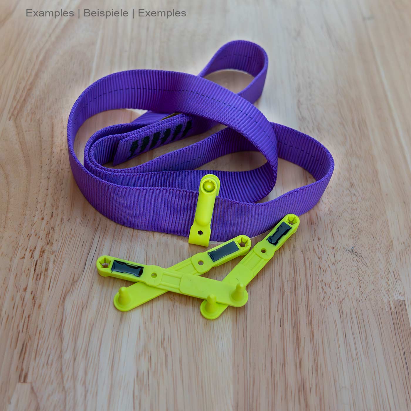 Trois boucles jaunes : une étiquette NFC de Scannable se trouve sur une table en bois à côté d’une boucle violette en tissu