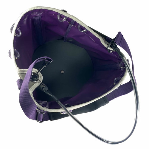 Genius Tool Bucket 2, vue de dessus du sac avec doublure violette, fond noir et cintre en métal, bretelles violettes visibles à l’extérieur