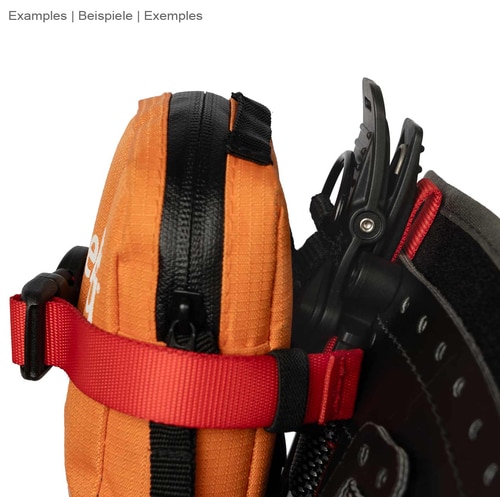 Caïman de DMM, ruban rouge attaché à un sac zippé orange avec fermeture velcro noire