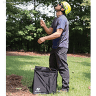 Homme en casque jaune et lunettes de soleil debout sur l’herbe et tenant une corde orange sur un Pro Folding Cube of Notch noir