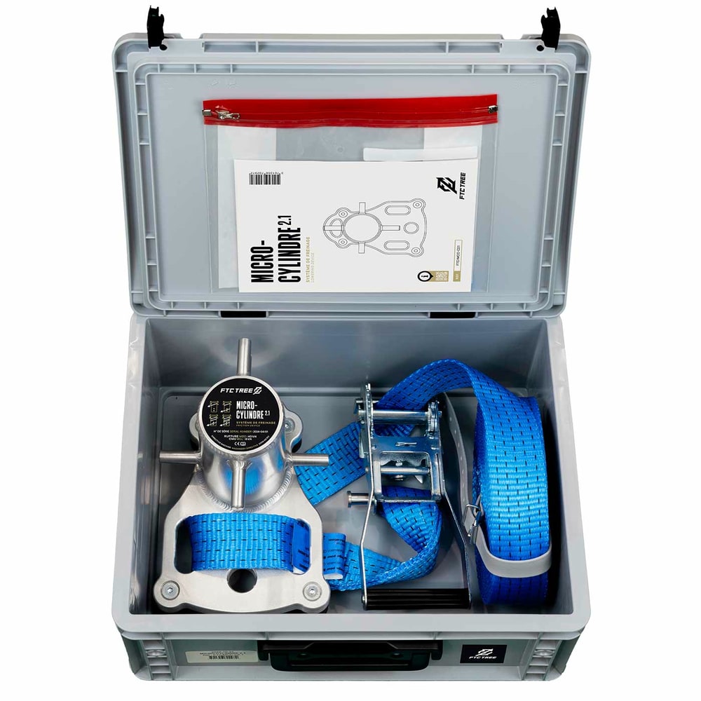Micro Cylindre 2.1 de FTC TREE dans un boîtier en plastique gris avec bracelet bleu, cliquet et instructions