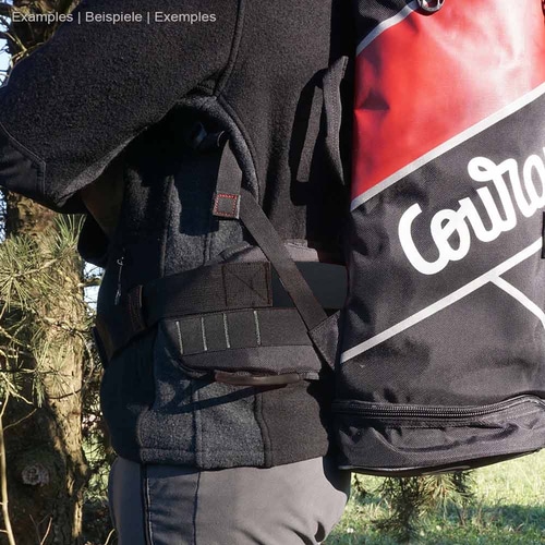 Personne portant une ceinture croisée noire avec l’inscription blanche « Courant » et un sac à dos rouge, fabricant non visible