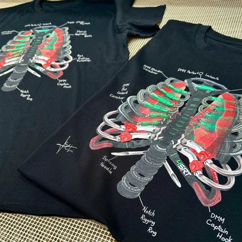 Deux t-shirts noirs Arb Ribs avec le motif de la cage thoracique imprimé sur eux à partir d’un équipement d’escalade sont posés l’un à côté de l’autre sur une surface