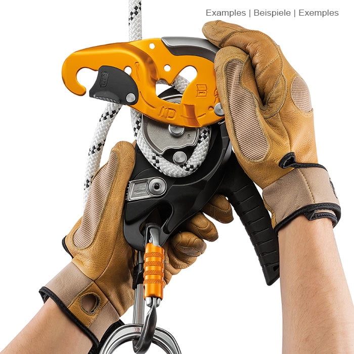 Les mains en gants de travail marron manœuvrent l’équipement d’escalade jaune et noir I’D S de Petzl avec une corde blanche