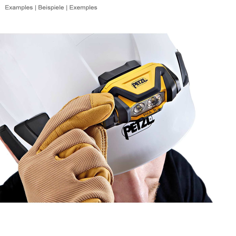 Lampe frontale Petzl Pixa R montée sur un casque de sécurité blanc, une main avec un gant de travail touche la lampe