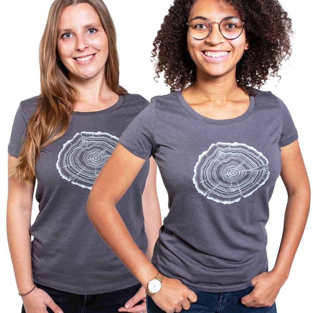 Deux femmes portent des t-shirts gris Treeslice Women avec un motif de tronc d’arbre blanc coupé sur le devant, une femme a de longs cheveux blonds, l’autre porte des lunettes et a des cheveux noirs bouclés