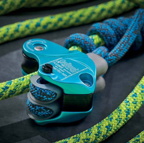 Flexbee gros plan de l’appareil d’assurage bleu avec corde d’escalade bleue et jaune sur fond noir
