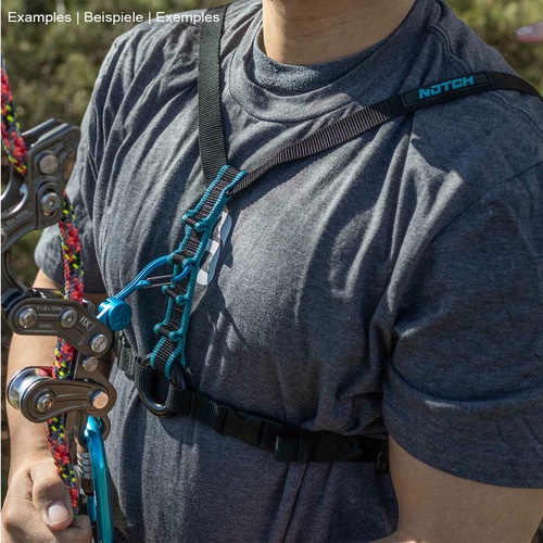 Personne portant un t-shirt gris et une sangle de poitrine Chester SRS noire avec surpiqûres turquoise, tenant un équipement d’escalade dans sa main gauche