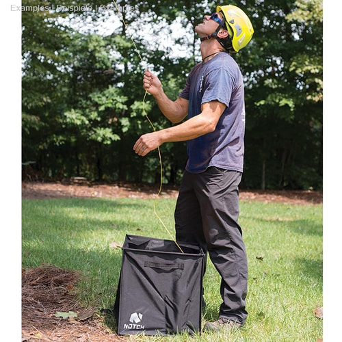 Homme en casque jaune et lunettes de soleil debout sur l’herbe et tenant une corde orange sur un Pro Folding Cube of Notch noir
