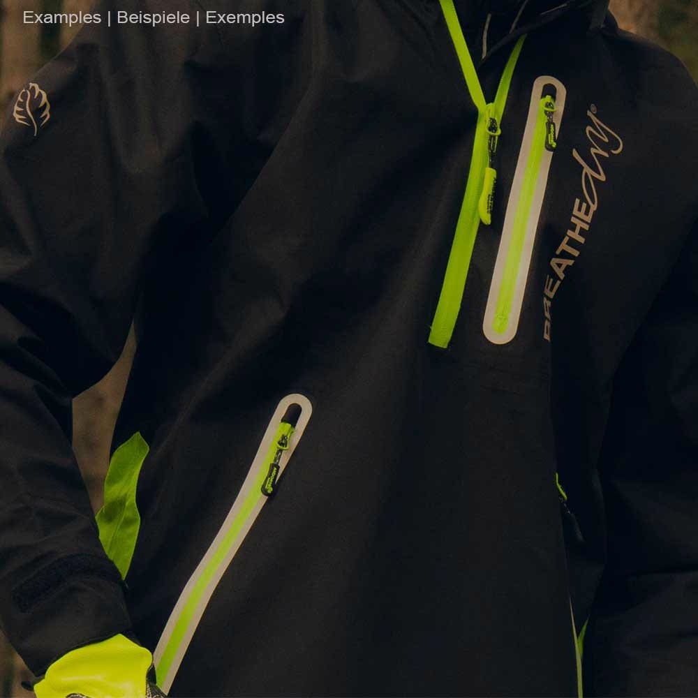 Gros plan d’une personne portant une veste smockée noire BreatheDry avec des détails verts et des poches zippées