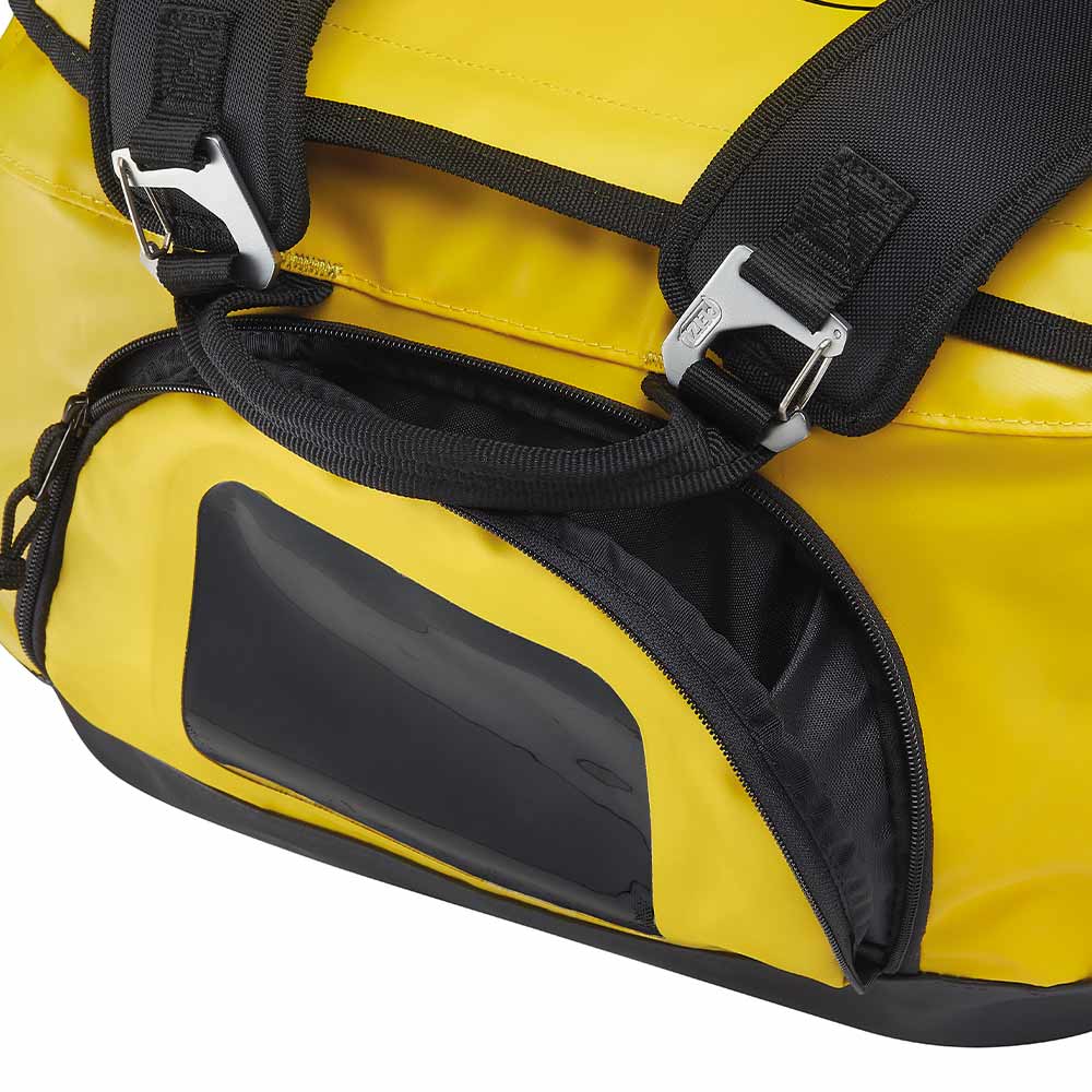 Détail des bretelles de transport noires et d’un compartiment latéral zippé du sac PETZL Duffel 85 jaune