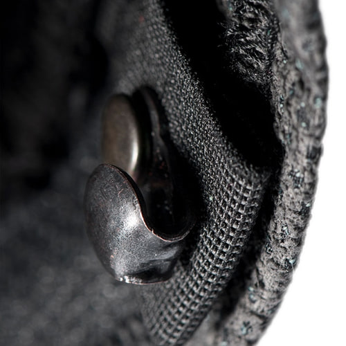 Gros plan d’un bouton en métal noir sur un tissu, faisant probablement partie du pantalon Arborist Progress