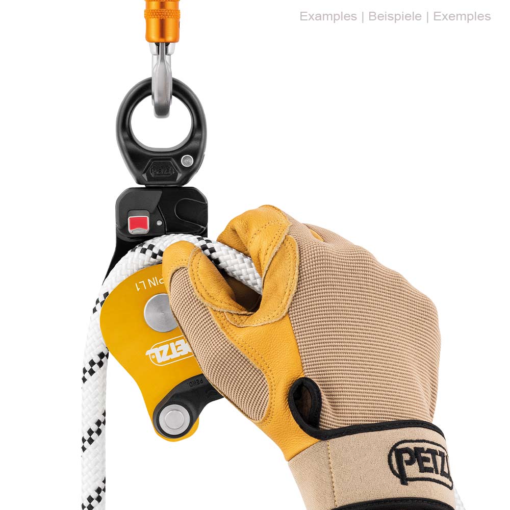 Poulie à corde Petzl Spin L1 avec corde blanche, tenue d’une main par des gants de travail, attachée à un mousqueton