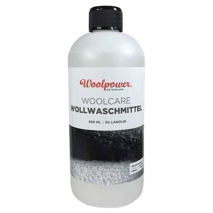Woolpower Woolcare Détergent pour laine 500 ml avec bouchon à vis noir et étiquette blanche avec texte noir et rouge