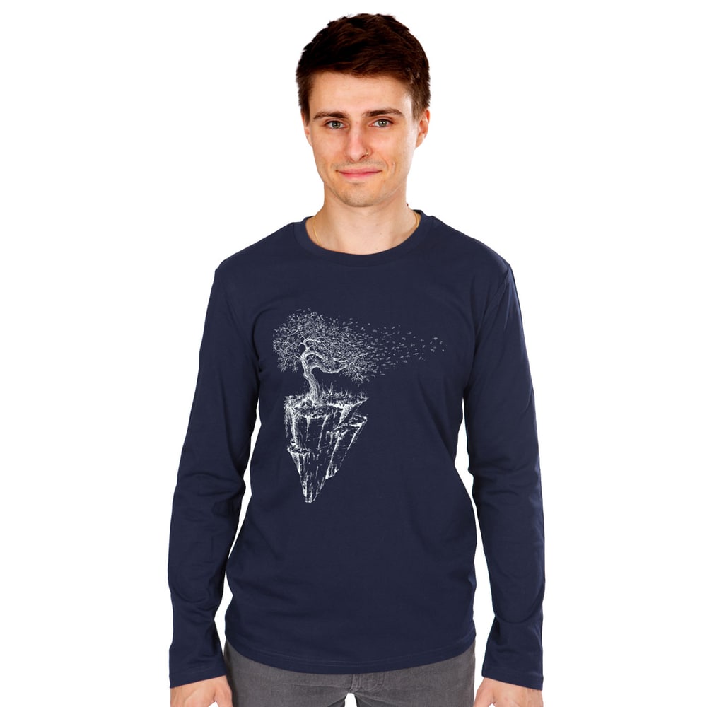 Iceland Longsleeve, chemise à manches longues bleu foncé avec motif blanc d’un arbre sur une île rocheuse flottante, portée par un jeune homme aux cheveux bruns