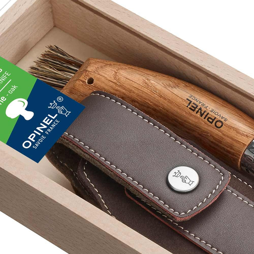 Détail de la poignée en bois avec l’inscription « OPINEL SAVOIE-FRANCE » et étui en cuir avec bouton dans la boîte en bois clair